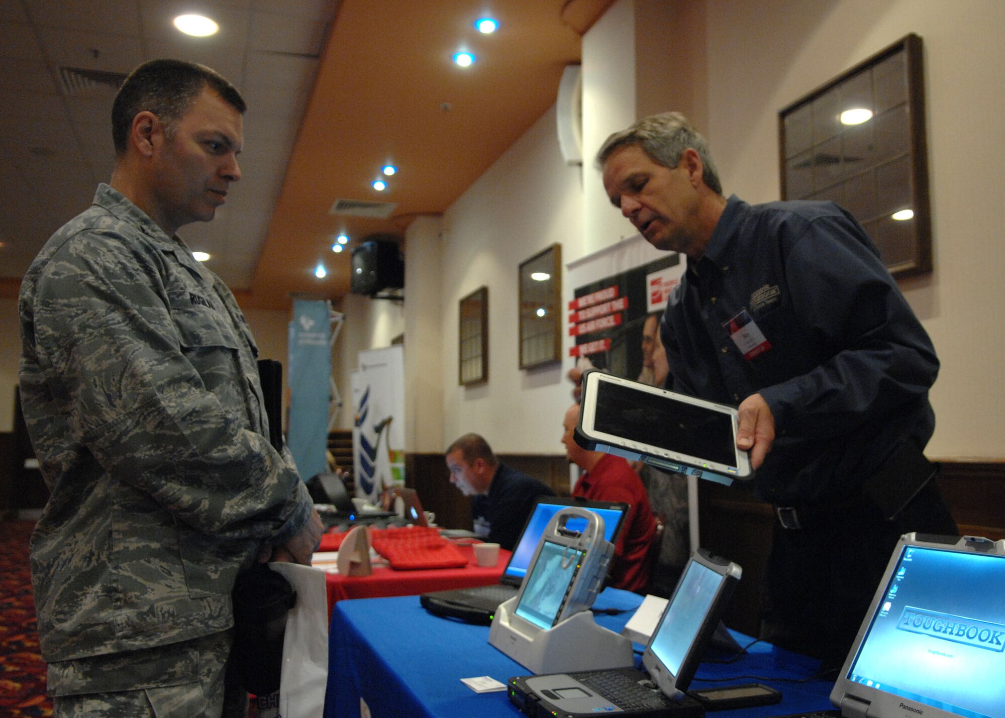 From left, Col. Joseph Rushlau, 100th Maintenance Group commander, examines electronics during a Technology Expo May 23, 2013, at the Galaxy Club on RAF Mildenhall, England. The exposition was hosted by the 100th Communications Squadron and had more than 25 different exhibits. (U.S. Air Force photo by Airman 1st Class Dillon Johnston/Released)