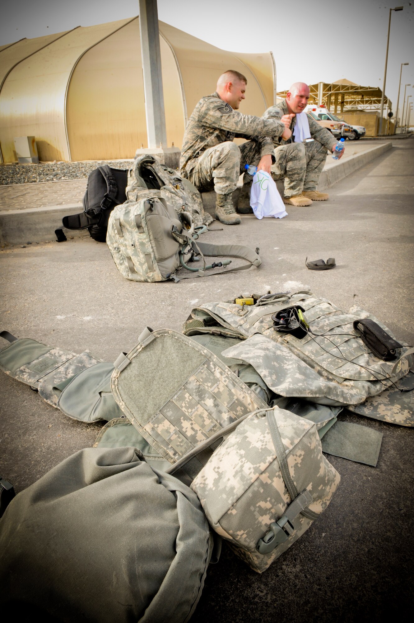 A pile of gear lays on the street after U.S. Air Force Tech. Sergeant Robert Kelly and U.S Air Force Staff Sgt. Matthew McNutt, both with the 380th Expeditionary Civil Engineer Squadron, finished the Bolder Boulder 10K run at an undisclosed location in Southwest Asia, May 23, 2013. Kelly and McNutt ruck marched the entire 10k with over 60lbs of extra weight to include their flak vests. Kelly hails from Winchester, Ind., and is deployed from Joint Base Elemendorf-Richardson and McNutt is a native of St. Joseph, Mo., and is deployed from Moody Air Force Base, Ga.  (U.S. Air Force photo by Staff. Sgt Joshua J. Garcia)