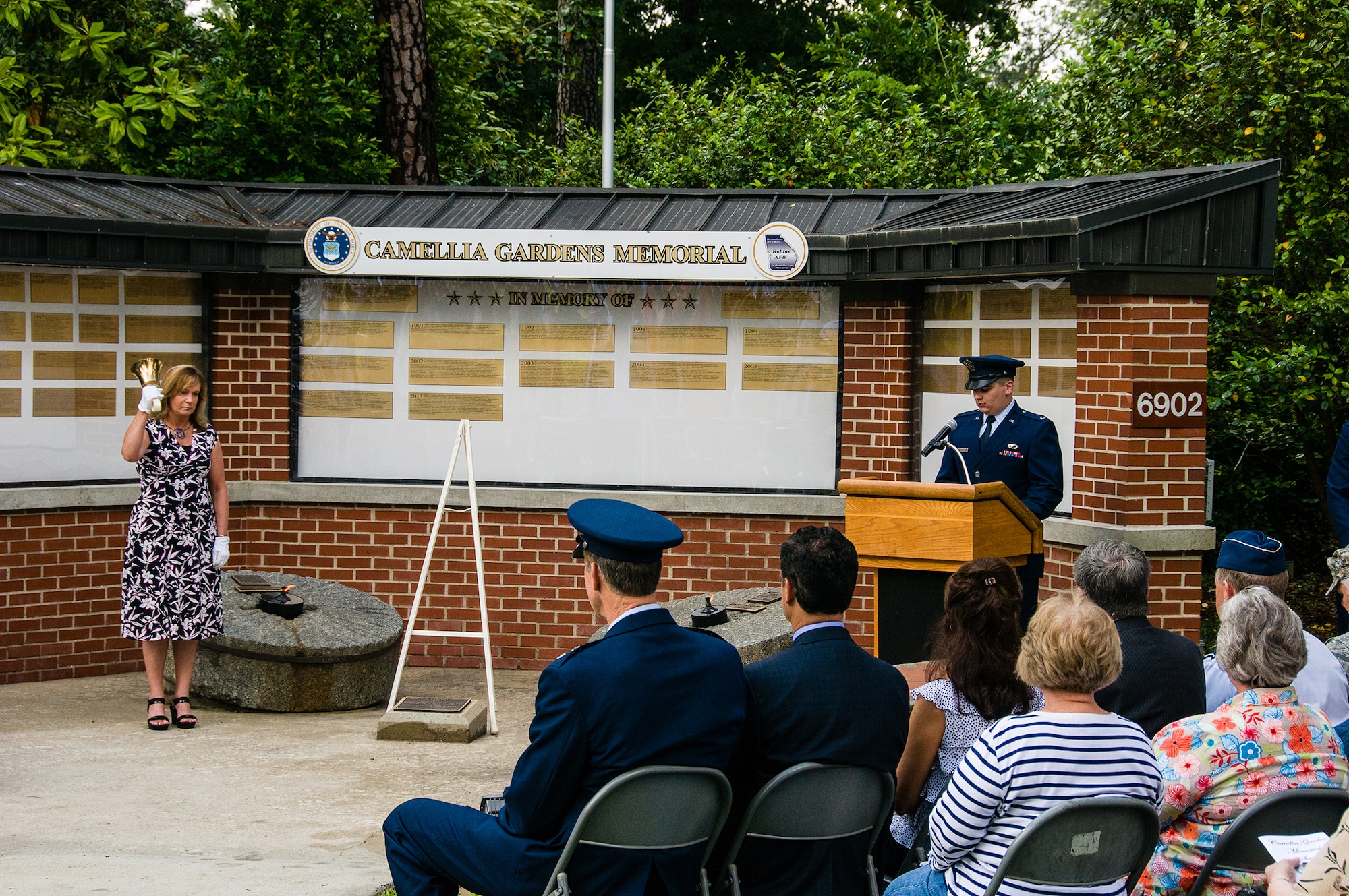 Margaret Scheer rings the bell after each name is read by 1st Lt. David Butzin May 23, 2013, on Robins Air Force Base, Ga. Members from Team Robins gathered at Camellia Gardens Memorial for a service honoring those who served the Robins AFB community and are no longer with us. This year, 59 names were added to the memorial. (U.S. Air Force photo/Staff Sgt. Alexi Saltekoff)