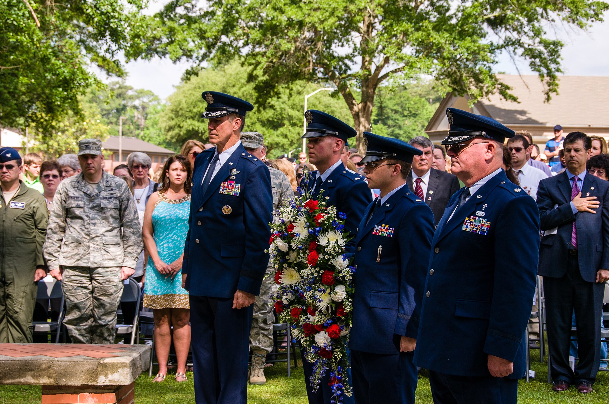 The wreath laying party, led by Maj. Gen. Craig Gourley, Air Force Reserve Command vice commander, pauses for the playing of Amazing Grace before placing the wreth at the memorial site May 23, 2013, on Robins Air Force Base, Ga. Members from Team Robins gathered at Camellia Garden Memorial for a service honoring those who served the Robins AFB community and are no longer with us. This year, 59 names were added to the memorial. (U.S. Air Force photo/Staff Sgt. Alexi Saltekoff)