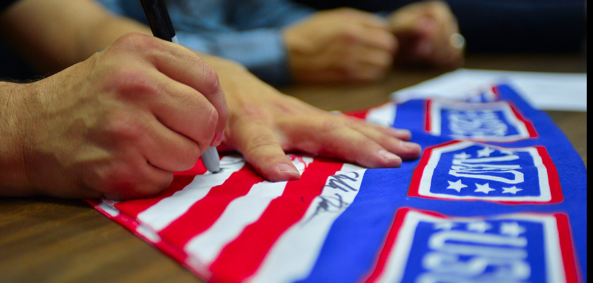 Members of the Traveling Guitar Foundation sign a USO bandana on Ramstein Air Base, Germany, May 21, 2013. Members of the foundation performed for wounded warriors and middle school students while visiting Ramstein. (U.S. Air Force photo/Airman 1st Class Jordan Castelan)