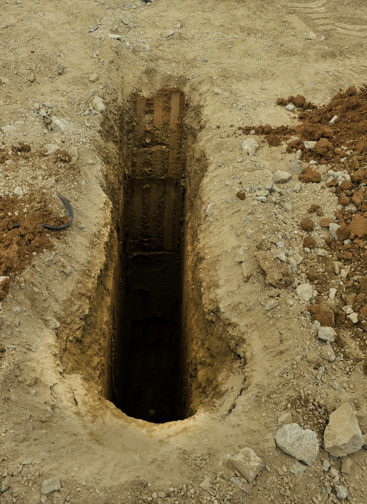 Members of the 455th Expeditionary Civil Engineer Squadron discuss the process for repairing a sinkhole on the runway ramp on Bagram Airfield, Afghanistan May 22, 2013. The CES was tasked with digging up the ramp to find the root cause of a dip that occurred overnight causing the concrete to come loose and pose risk to the aircraft. (U.S. Air Force photo/ Staff Sgt. Stephenie Wade)