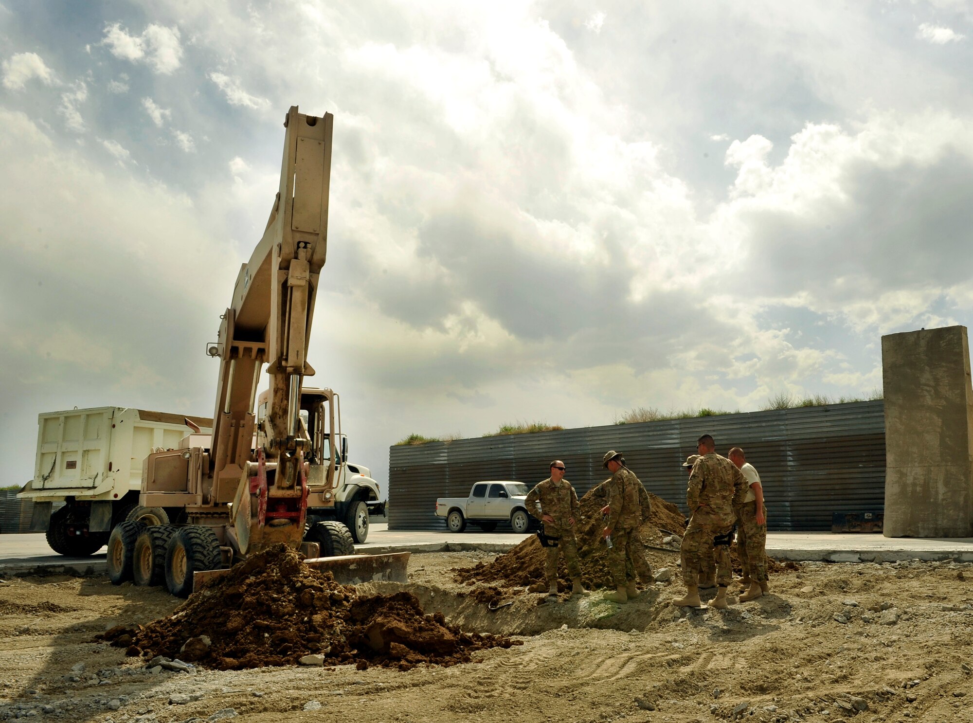 Members of the 455th Expeditionary Civil Engineer Squadron discuss the process for repairing a sinkhole on the runway ramp on Bagram Airfield, Afghanistan May 22, 2013. The CES was tasked with digging up the ramp to find the root cause of a dip that occurred overnight causing the concrete to come loose and pose risk to the aircraft. (U.S. Air Force photo/ Staff Sgt. Stephenie Wade)