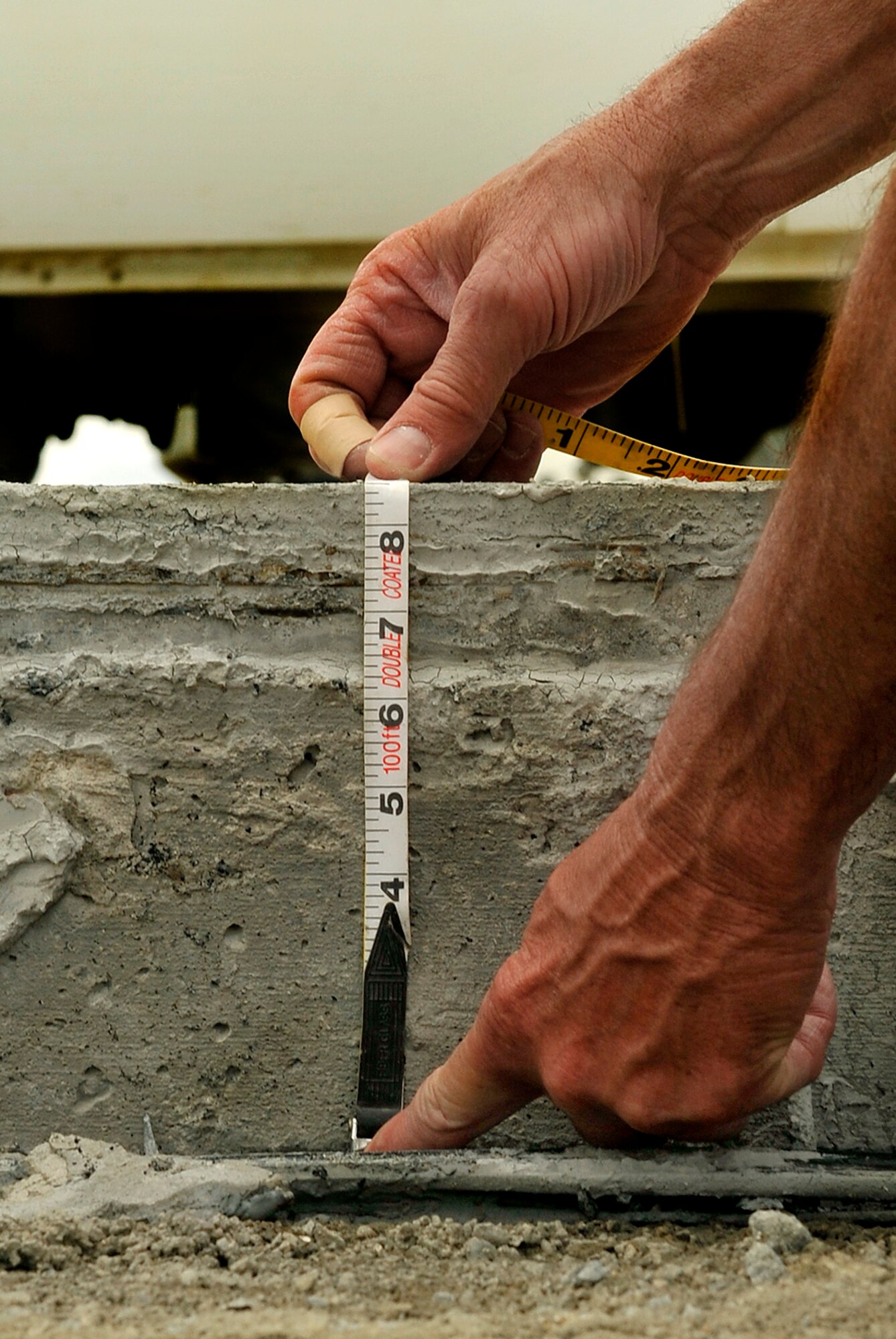 Master Sgt. Jeffrey Young, 455th Expeditionary Civil Engineer heavy equipment superintendent, measures the depth of the concrete slab on the runway ramp on Bagram Airfield, Afghanistan, May 22, 2013. The depth will be compared to the measurement used on the original ramp construction to determine the amount concrete to need in the future. Young is deployed from Charlotte Air National Guard Base, N.C. (U.S. Air Force photo/ Staff Sgt. Stephenie Wade)