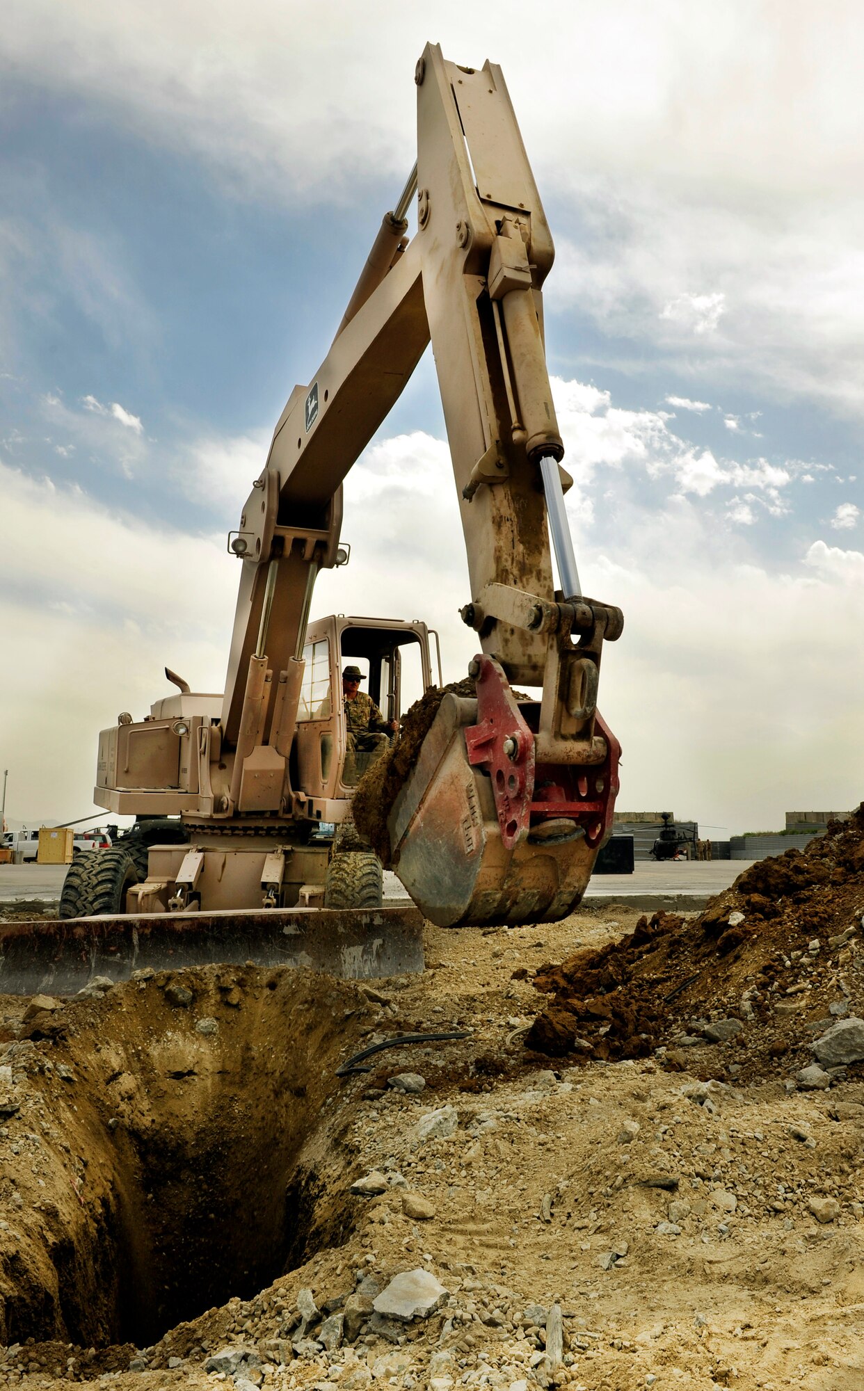 Airmen assigned to the 455th Expeditionary Civil Engineer Squadron remove damaged concrete on a runway ramp before placing new slabs on Bagram Airfield, Afghanistan, May 22, 2013. The CES was tasked with digging up the ramp to find the root cause of a dip that occurred overnight causing the concrete to come loose and pose risk to the aircraft. The “Dirt Boyz” are deployed from Charlotte Air National Guard Base, N.C.  (U.S. Air Force photo/Staff Sgt. Stephenie Wade)
