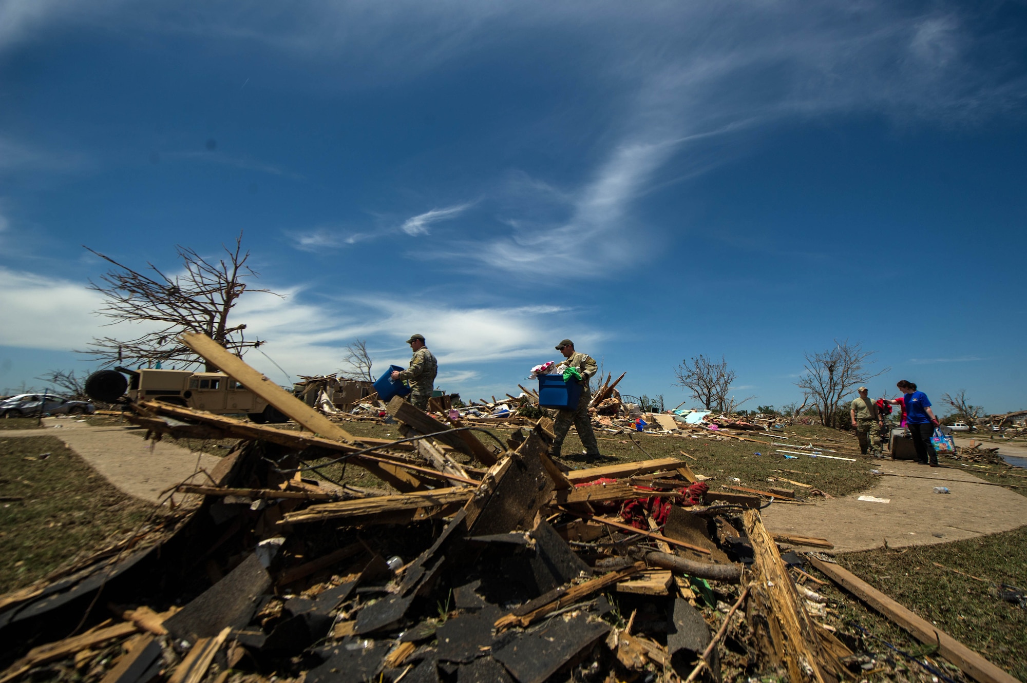 Airmen help a resident search through the debris looking for salvageable items May 22, 2013, in Moore, Okla.  An EF-5 tornado, with winds reaching at least 200 mph, traveled for 20 miles, leaving a two-mile-wide path of destruction, leveling homes, crushing vehicles, and killing more than 20 people May 20, 2013. More than 115 Oklahoma National Guard members have been activated to assist in the rescue and relief efforts.  (U.S. Air Force photo/Staff Sgt. Jonathan Snyder)  