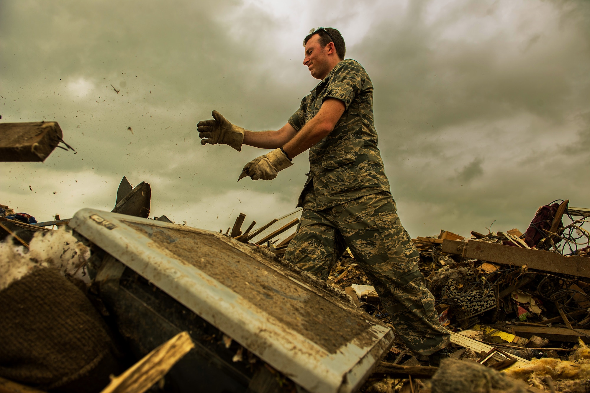 U.S. Air Force Capt. Ryan Gers, searches through the rubble of a leveled home, May 23, 2013, looking for anything salvageable after a tornado ripped through parts of Moore, Okla., May 20, which damaged more than 13,000 homes. More than 600 Airmen from the greater Oklahoma area volunteered to assist in the relief efforts. Gers is assigned to the 965th Airborne Air Control Squadron, Tinker Air Force Base, Okla., and hails from Scottsdale, Ariz. (U.S. Air Force photo by Staff Sgt. Jonathan Snyder)