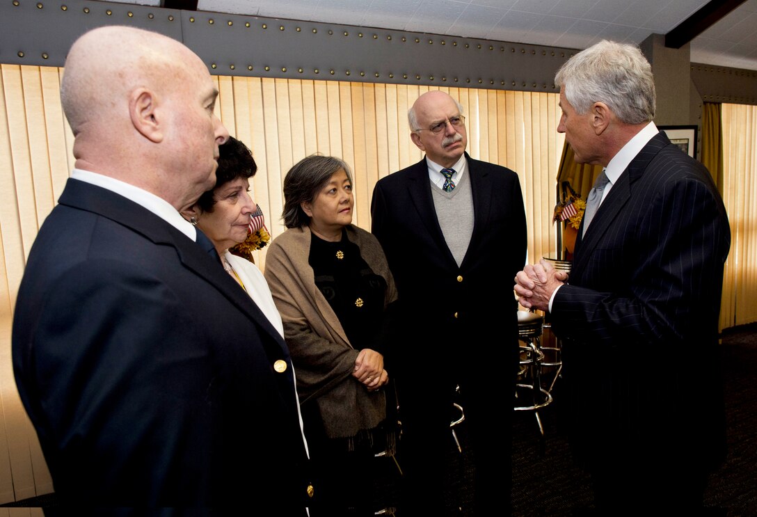 Defense Secretary Chuck Hagel stands and speaks with a group of people.
