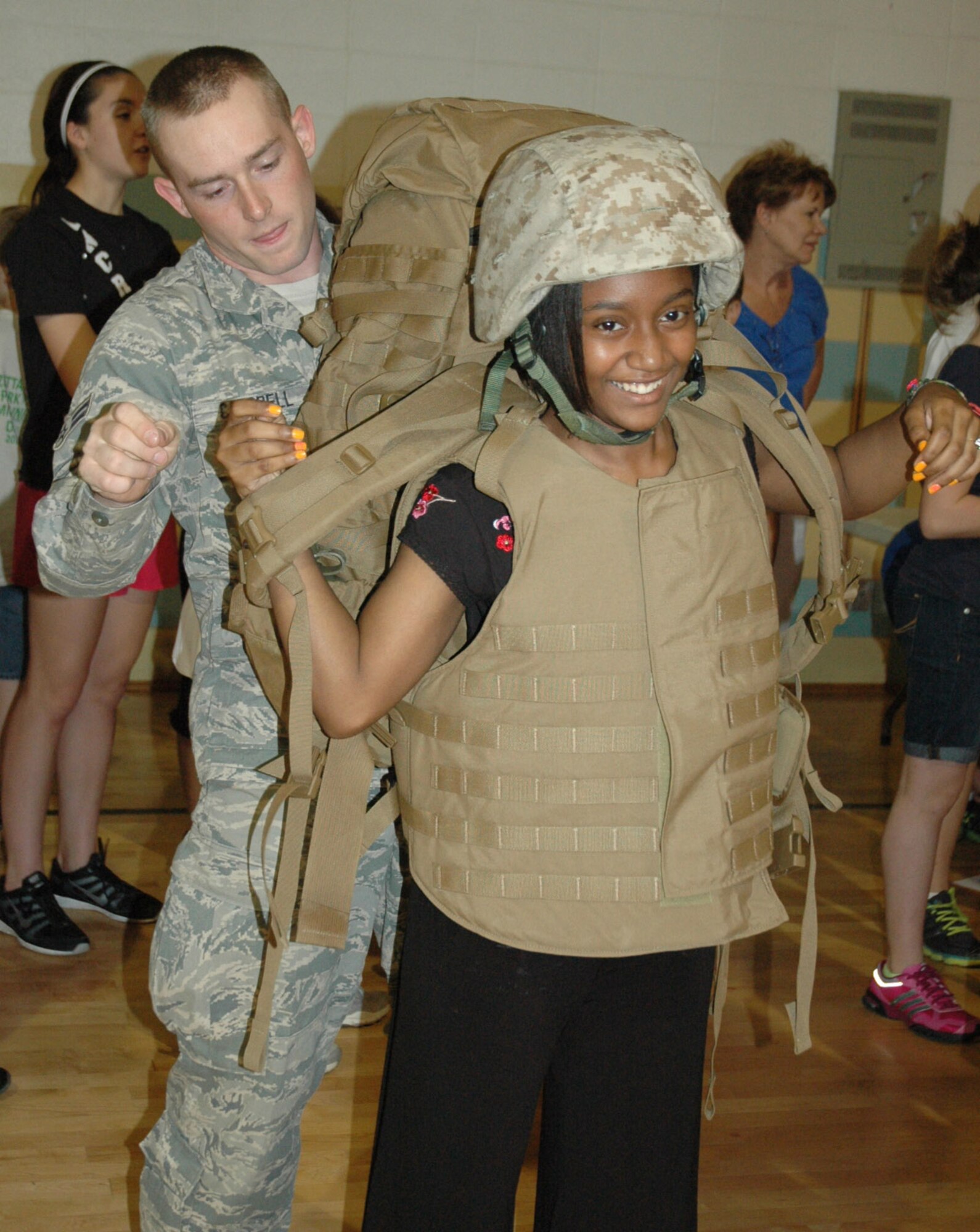 Air Force Reserve Airman 1st Class Brandon Campbell, a member of the 910th Security Forces Squadron, helps a student try on a military issue flak vest at Lakeview Middle School May 17, 2013. Several members of the 910th Airlift Wing volunteered to interact with students during Right to Read week. (Courtesy photo)
