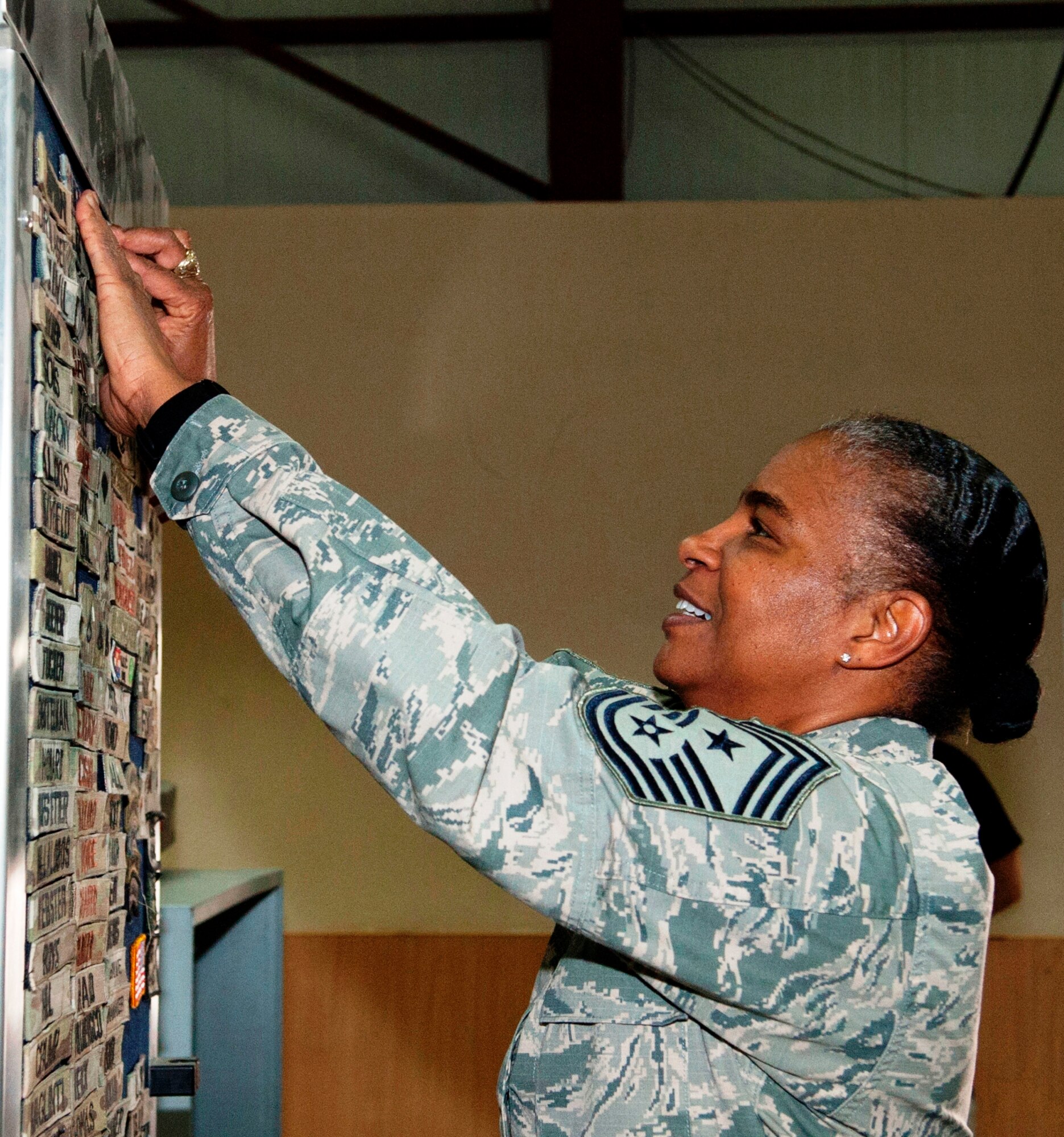 Chief Master Sgt. Shelina Frey adds a name tag to the passenger terminal's “Wall of Fame” at Transit Center at Manas, Kyrgyzstan, May 14, 2013. Frey toured the Transit Center as the new U.S. Air Forces Central Command command chief. (U.S. Air Force photo/Staff Sgt. Robert Barnett)