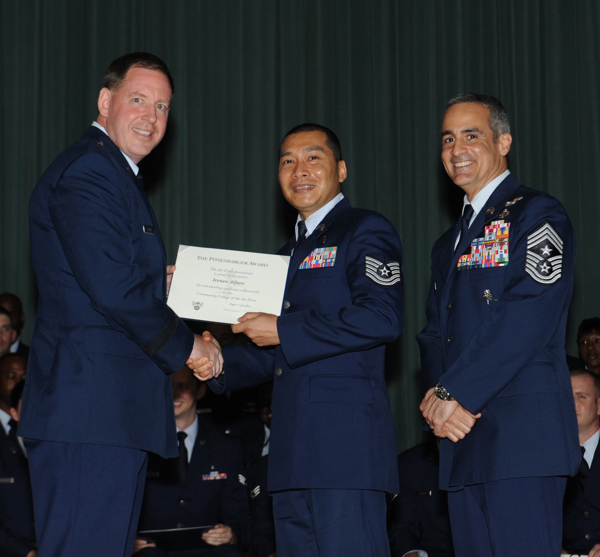 U.S. Air Force Tech. Sgt. Ireneo Alfaro, 18th Aerospace Medicine Squadron NCO in charge of community health element, receives the Pitsenbarger Award during a Community College of the Air Force graduation ceremony at the Keystone Theater on Kadena Air Base, Japan, May 22, 2013. A CCAF degree, requiring at least 64 college credit hours, is essential for U.S. Air Force Airmen in order to progress through the enlisted ranks and further their careers. (U.S. Air Force photo by Airman 1st Class Malia Jenkins/Released)