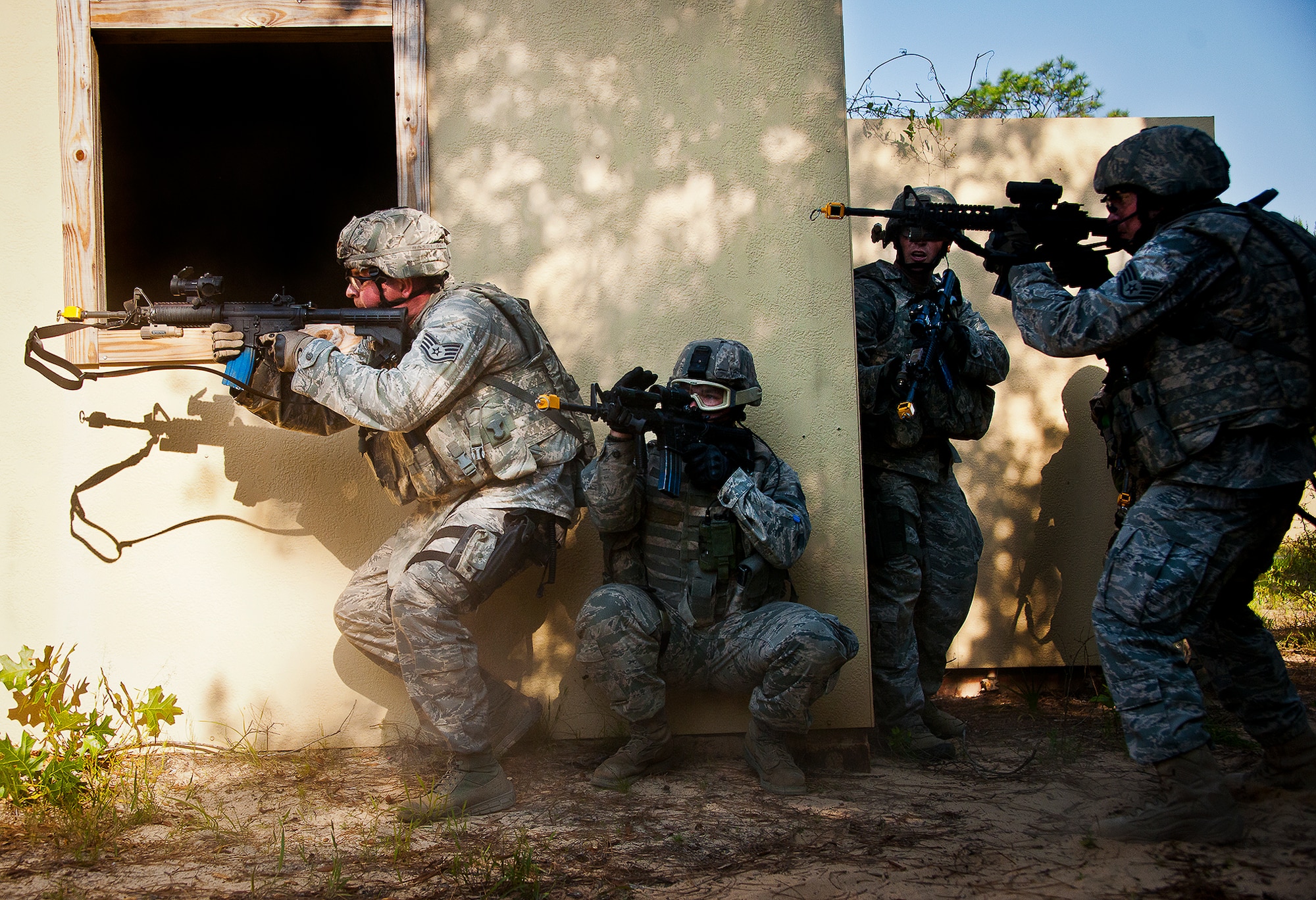 A four-person fire team move in to clear a building during an assault on a village at the end of the three-day Brave Defender field training exercise May 20 at Eglin Air Force Base, Fla.  The exercise is the culmination of Air Force Materiel Command’s six-week security forces deployment training, administered by the 96th Ground Combat Training Squadron. GCTS instructors teach 10 training classes a year, which consists of improvised explosive device detection and reaction, operating in an urban environment, mission planning, land navigation and casualty care and more. More than 140 active-duty and National Guard Airmen attended this training. (U.S. Air Force photo/Samuel King Jr.)