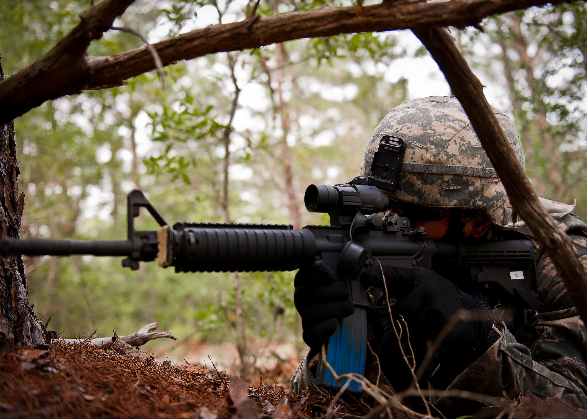 Senior Airman William Whitlow, of the 164th Security Forces Squadron, scans the area from a prone position during a dismounted patrol as part of the three-day Brave Defender field training exercise May 19 at Eglin Air Force Base, Fla.  The exercise is the culmination of Air Force Materiel Command’s six-week security forces deployment training, administered by the 96th Ground Combat Training Squadron. GCTS instructors teach 10 training classes a year, which consists of improvised explosive device detection and reaction, operating in an urban environment, mission planning, land navigation and casualty care and more. More than 140 active-duty and National Guard Airmen attended this training. (U.S. Air Force photo/Samuel King Jr.)