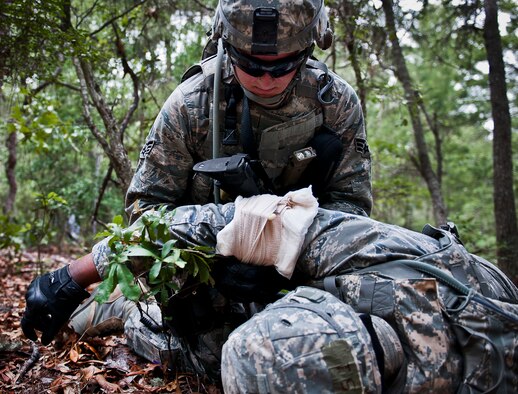 Senior Airman Ian Barnes, of the 164th Security Forces Squadron, performs buddy-care on a wounded Airman after a fire-fight while on a dismounted patrol during the three-day Brave Defender field training exercise May 19 at Eglin Air Force Base, Fla.  The exercise is the culmination of Air Force Materiel Command’s six-week security forces deployment training, administered by the 96th Ground Combat Training Squadron. GCTS instructors teach 10 training classes a year, which consists of improvised explosive device detection and reaction, operating in an urban environment, mission planning, land navigation and casualty care and more. More than 140 active-duty and National Guard Airmen attended this training. (U.S. Air Force photo/Samuel King Jr.)