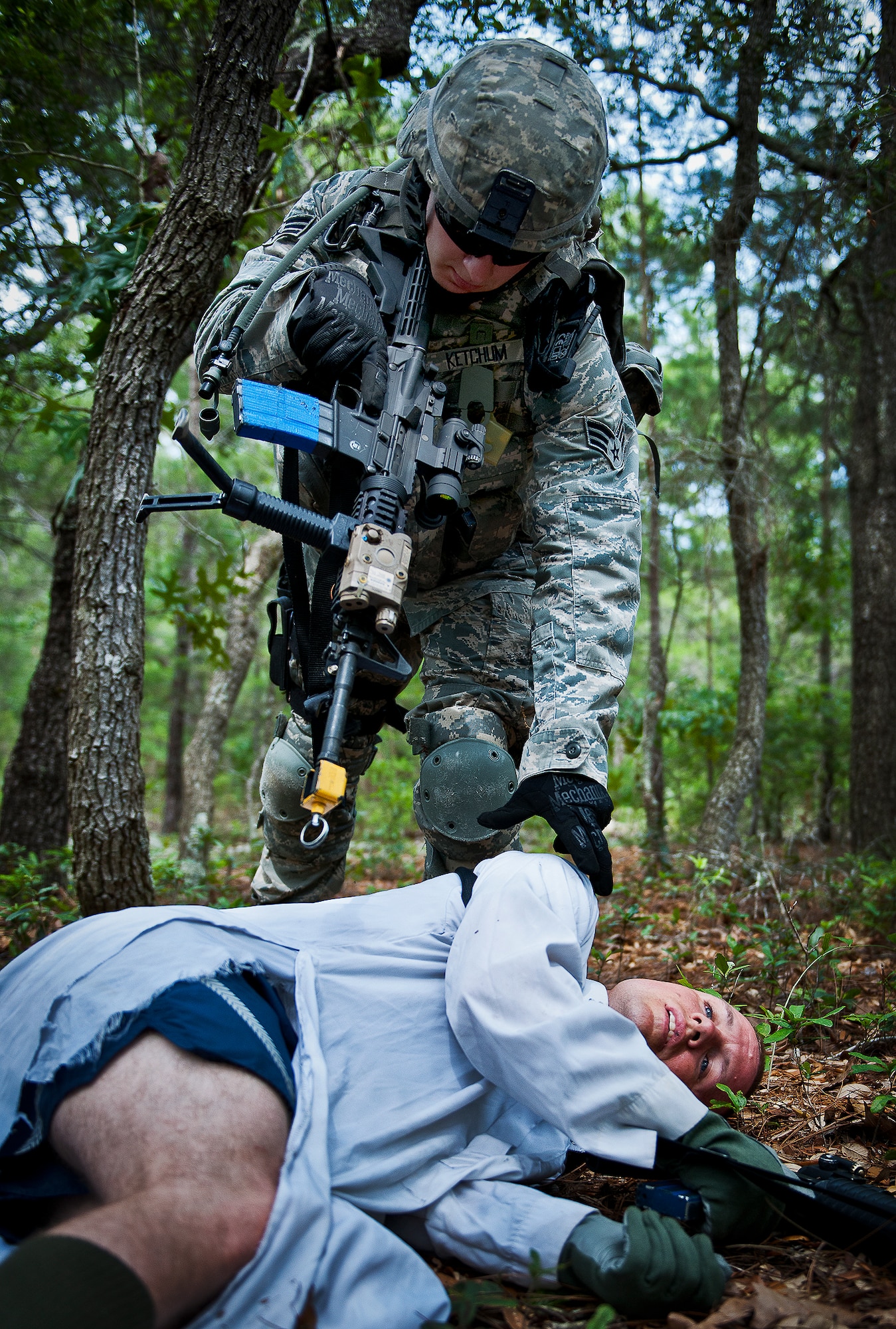 Senior Airman Jesse Kethum, of the 164th Security Forces Squadron, examines an enemy combatant after a fire-fight while on a dismounted patrol during the three-day Brave Defender field training exercise May 19 at Eglin Air Force Base, Fla.  The exercise is the culmination of Air Force Materiel Command’s six-week security forces deployment training, administered by the 96th Ground Combat Training Squadron. GCTS instructors teach 10 training classes a year, which consists of improvised explosive device detection and reaction, operating in an urban environment, mission planning, land navigation and casualty care and more. More than 140 active-duty and National Guard Airmen attended this training. (U.S. Air Force photo/Samuel King Jr.)
