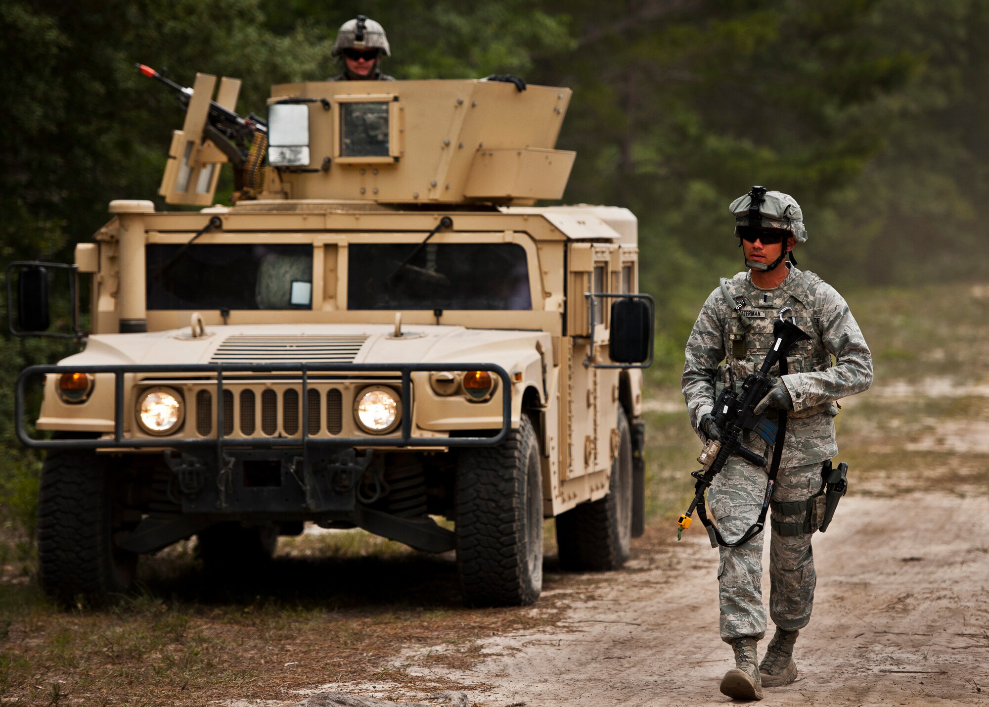 1st Lt. Sam Waterman, of the 90th Security Forces Squadron, walks beside a HMMWV as it patrols the perimeter of the base during the three-day Brave Defender field training exercise May 19 at Eglin Air Force Base, Fla.  The exercise is the culmination of Air Force Materiel Command’s six-week security forces deployment training, administered by the 96th Ground Combat Training Squadron. GCTS instructors teach 10 training classes a year, which consists of improvised explosive device detection and reaction, operating in an urban environment, mission planning, land navigation and casualty care and more. More than 140 active-duty and National Guard Airmen attended this training. (U.S. Air Force photo/Samuel King Jr.)