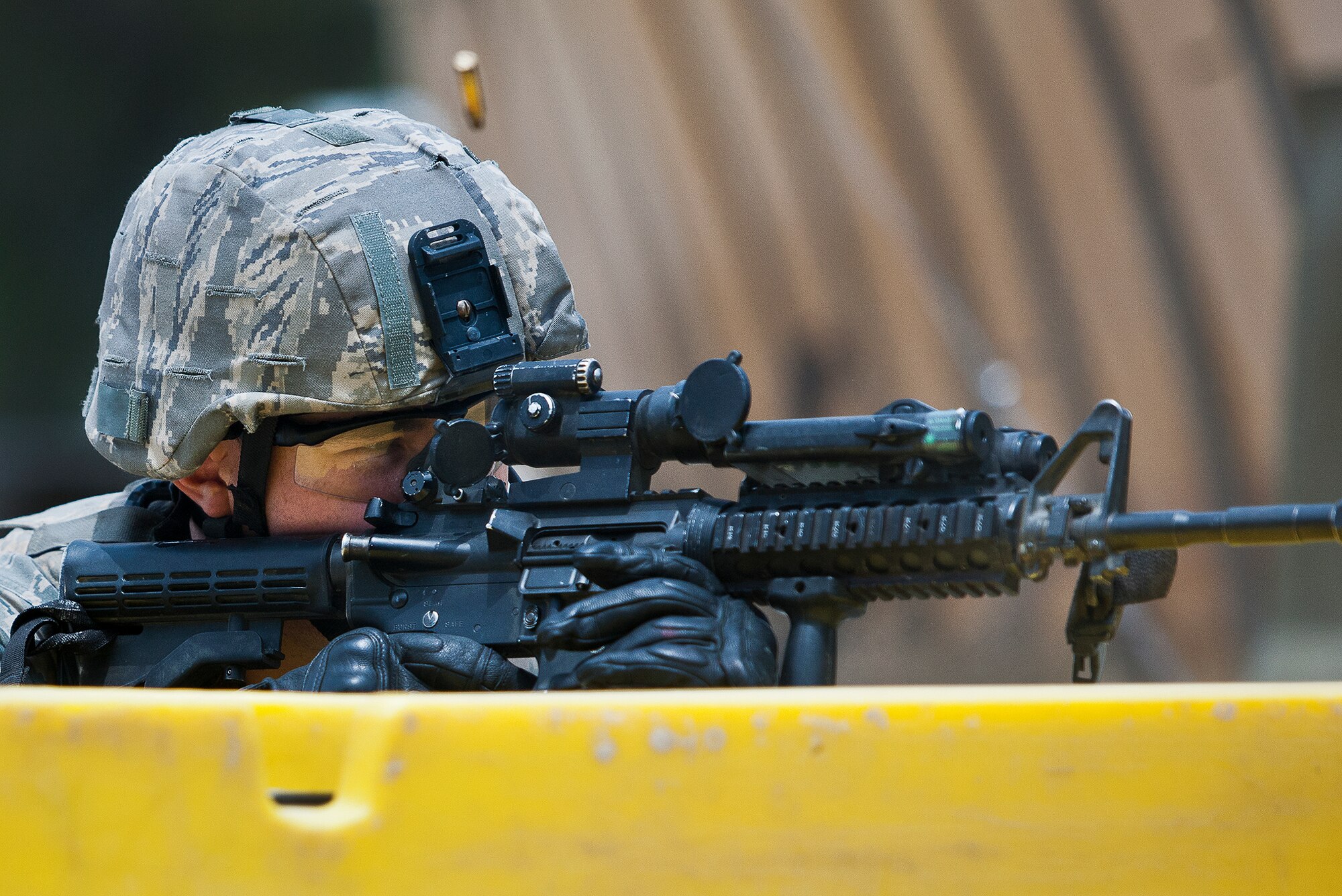 A Security Forces Airman fires his weapon from behind cover during an enemy assault on an entry control point at the three-day Brave Defender field training exercise May 19 at Eglin Air Force Base, Fla.  The exercise is the culmination of Air Force Materiel Command’s six-week security forces deployment training, administered by the 96th Ground Combat Training Squadron. GCTS instructors teach 10 training classes a year, which consists of improvised explosive device detection and reaction, operating in an urban environment, mission planning, land navigation and casualty care and more. More than 140 active-duty and National Guard Airmen attended this training. (U.S. Air Force photo/Samuel King Jr.)