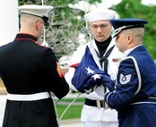 Members of the United States Transportation Command Joint Honor Guard unfold and hook the American flag to the flag while reveille plays during a Memorial Day Remembrance event held at the 375th Air Mobility Wing headquarters building May 27, 2013. On May 5, 1868 General John A. Logan, commander-in-chief of the Grand Army of the Republic, issued a proclamation that "Decoration Day" should be observed nationwide and annually. Later that year on May 30 it was observed for the first time. (U.S. Air Force photo/Staff Sgt. Teresa M. Jennings)