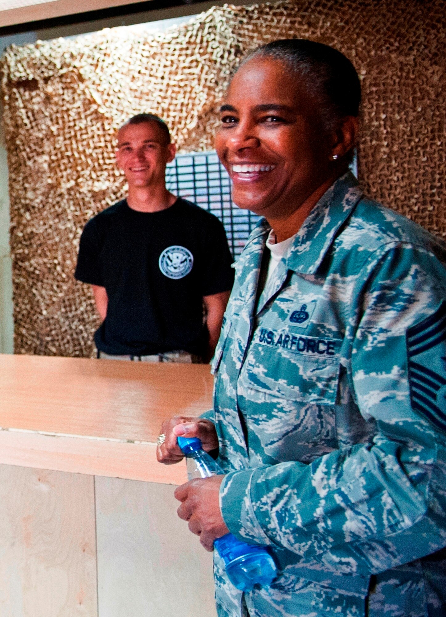 Chief Master Sgt. Shelina Frey, command chief for U.S. Air Forces Central Command, jokes with U.S. Army Spc. Skylar Lopp at the customs customer service desk at Transit Center at Manas, Kyrgyzstan, May 14, 2013. Lopp is a customs border agent for the 304th Military Police Battalion, Detachment 5. (U.S. Air Force photo/Staff Sgt. Robert Barnett)