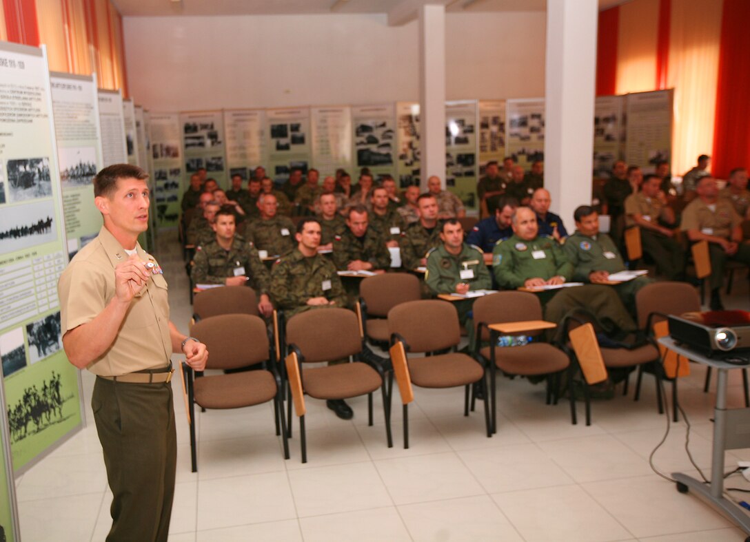 Captain Daniel "Hungry" Hipol, delivers a brief on Forward Air Controller-Airborne at the first ever Polish Air-Ground Integration conference, held at the Polish Armed Forces Artillery and Weapons Training Center in Torun, Poland, May 21-23.  Polish Armed Forces, with direct support from Marine Forces Europe and Marine Corps Security Group, hosted the regional conference in a concerted effort to improve close air support, joint terminal attack control, and fires integration skills between the partner nations involved. Aviators and service members from Latvia, Lithuania, Romania, and Slovenia, as well as the U.S. and Poland met in Torun to enhance their aviation and ground interoperability and partnership capacity. Hipol is a AH-1W Cobra Attack Helicopter pilot and platoon commander with 1st Air Naval Gunfire Liaison Company out of Camp Pendleton, Calif.