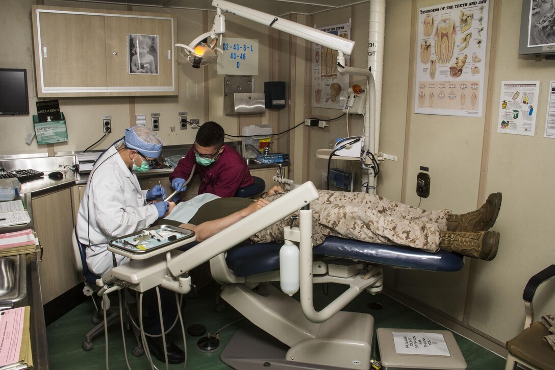 U.S. Navy Hospitalman Justin Sobleskie (right), line corpsman from Severn, Md., assigned to Company K, Battalion Landing Team (BLT) 3/2, 26th Marine Expeditionary Unit (MEU), and U.S. Navy Lt. Matthew Roberts, USS Carter Hall dental department head from Nantucket, Mass., do dental work on Hospitalman 3rd Class Shane Murphy, line corpsman from Spokane, Wash., with Tank Platoon, BLT 3/2, 26th MEU, aboard the USS Carter Hall (LSD 50) while at sea May 26, 2013. The 26th MEU is a Marine Air-Ground Task Force forward-deployed to the U.S. 5th Fleet area of responsibility aboard the Kearsarge Amphibious Ready Group serving as a sea-based, expeditionary crisis response force capable of conducting amphibious operations across the full range of military operations.
(U.S. Marine Corps photo by Cpl. Michael S. Lockett/Released)