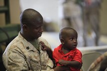A Marine with Retrograde and Redeployment in support of Reset and Reconstitution Operations Group, or R4OG, 2nd Marine Logistics Group holds his son one last time before embarking on a deployment aboard Camp Lejeune, N.C., May 16, 2013. More than 100 reservist and 50 active-duty service members were organized into the R4OG to gather Marine Corps equipment in Afghanistan and bring it back to the United States for redistribution. 