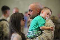 A Marine with Retrograde and Redeployment in support of Reset and Reconstitution Operations Group, 2nd Marine Logistics Group says goodbye to his wife and child before embarking on a deployment to Afghanistan aboard Camp Lejeune, N.C., May 16, 2013. The service members with the unit were expected to spend seven months in Afghanistan to complete their mission of reorganizing, repairing and shipping Marine Corps equipment back to the United States. 