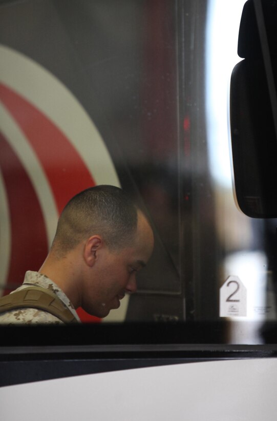 A service member with Retrograde and Redeployment in support of Reset and Reconstitution Operations Group, or R4OG, 2nd Marine Logistics Group boards a bus prior to the unit’s deployment aboard Camp Lejeune, N.C., May 16, 2013. R4OG’s mission during the seven-month deployment is to organize weapons, vehicles and other equipment belonging to the Marine Corps before shipping to the United States for redistribution.