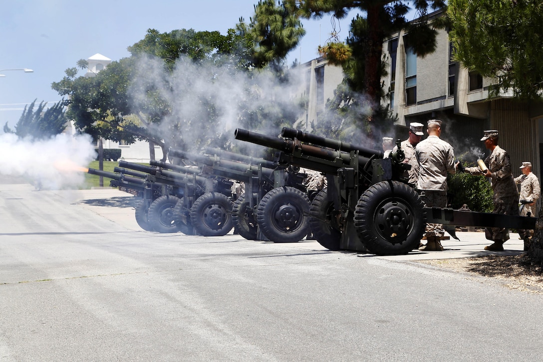 Four 105mm Howitzers fire in rhythmic succession during a ceremonial 21-gun salute held at the Marine Corps Installations-West Command building here on Memorial Day May 27. Kilo Battery, 3rd Battalion, 12th Marine Regiment operated the guns and performed the ceremony below the national ensign flown at half-mast in remembrance of service members that have paid the ultimate sacrifice for their country. 