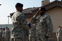Senior Airman Kyle Miller-Lawson, 8th Security Forces Squadron, salutes the flag after folding it during a memorial retreat ceremony at Kunsan Air Base, Republic of Korea, May 15, 2013. Miller-Lawson and others participated in a special retreat in honor of National Police Week. (U.S. Air Force photo by Staff Sgt. Jonathan Fowler/Released)