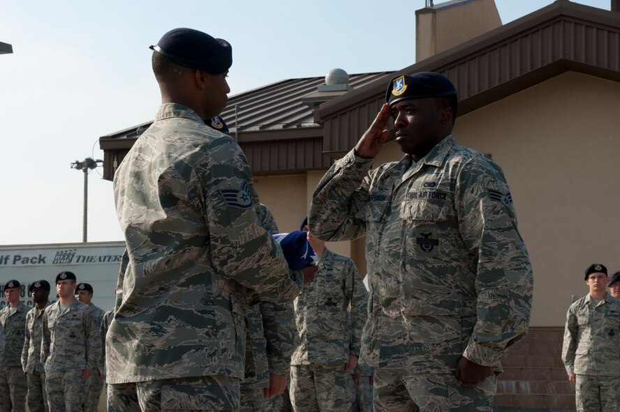 Senior Airman Kyle Miller-Lawson, 8th Security Forces Squadron, salutes the flag after folding it during a memorial retreat ceremony at Kunsan Air Base, Republic of Korea, May 15, 2013. Miller-Lawson and others participated in a special retreat in honor of National Police Week. (U.S. Air Force photo by Staff Sgt. Jonathan Fowler/Released)