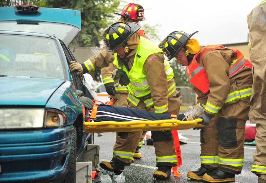 92nd Civil Engineer Squadron firefighters extract a simulated victim of a car accident from a vehicle during a demonstration at Fairchild Air Force Base, Wash., May 22, 2013. Fairchild firefighters provide the base with firefighting protection including medical, crash and structural emergencies. (U.S. Air Force photo by Senior Airman Taylor Curry/Released)