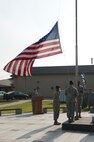 8th Security Forces Squadron members salute as the flag is lowered during a memorial retreat at Kunsan Air Base, Republic of Korea, May 15, 2013. The retreat was a special ceremony during National Police Week in honor of fallen law enforcement professionals. (U.S. Air Force photo by Staff Sgt. Jonathan Fowler/Released)