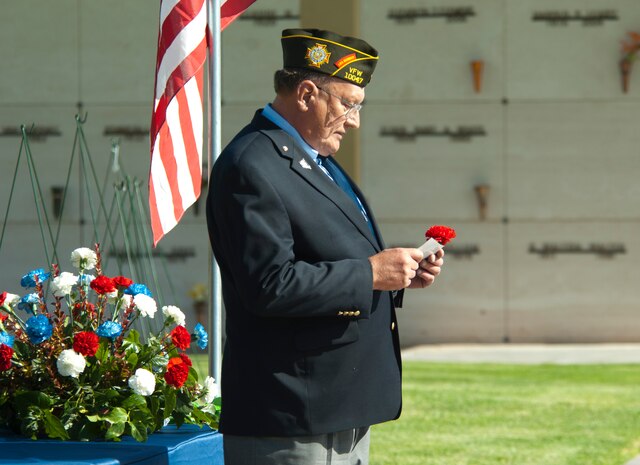 Russ Koller, a member of the Veterans of Foreign Wars North Las Vegas Post 10047, explains the symbolic significance of red poppies before laying one onto a table during Memorial Day ceremonies at Bunkers Memory Gardens, a cemetery in North Las Vegas, Nev., May 27, 2013. The Poppy Flowers are the official flower of remembrance for the VFW and their red color symbolizes their fallen comrade’s love for country, and the blood that they have shed. (U.S. Air Force Photo by Staff Sgt. Gregory Brook)