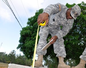 United States Army Master Sgt. Dunte Bennett Joint Task Force-Bravo Engineer Non-commissioned Officer in Charge measures the completed sewer system at the Honduran army base Mocoron, May 21. The team, led by Honduran military engineers, is conducting a topographical survey of the current infrastructure, to begin planning the next stage of facility upgrades. (U.S. Air Force photo by Staff Sgt. Eric Donner)