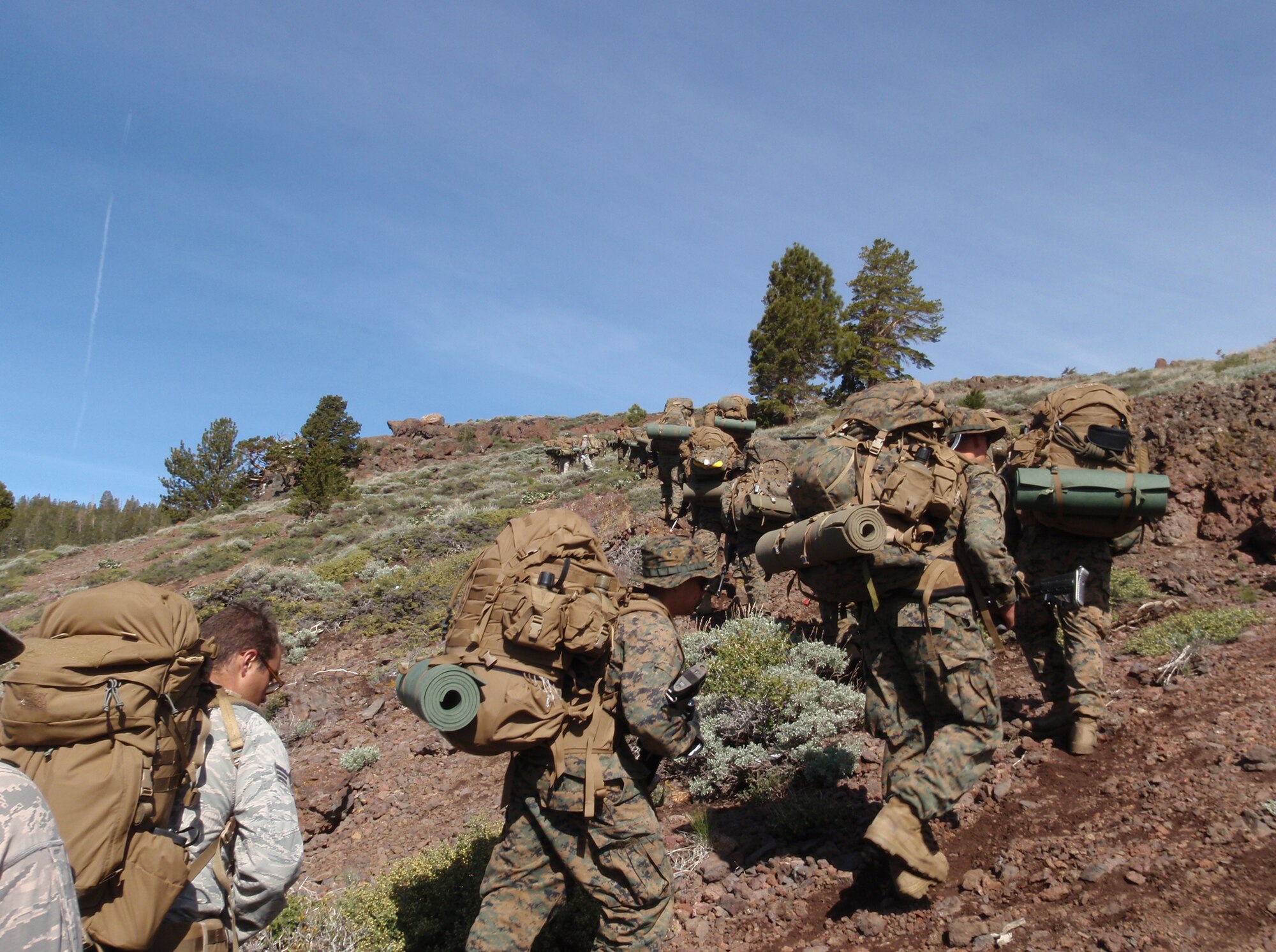 Airmen and Marines participate in a ruck march during Mountain Warfare Training at the Mountain Warfare Training Center, California, May 5, 2012. Participants are required to carry many items such as sleeping bags, water, food, first-aid kits and more. (Courtesy Photo)