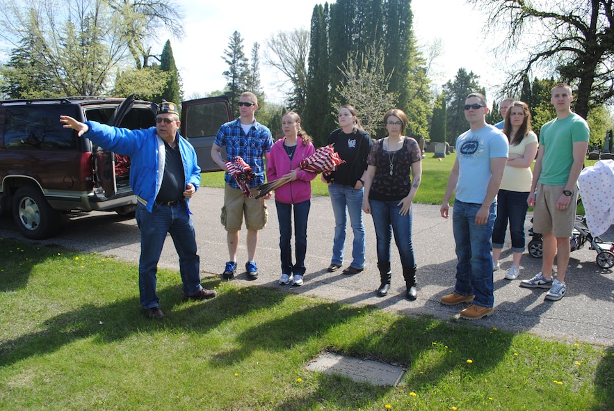Retired Senior Master Sgt. Bob Greene, American Legion Post 6 commander, shows a group of volunteers where to place U.S. flags at Calvary Cemetery in Grand Forks, N.D., on May 24, 2013.  More than 100 Airmen and family members from Grand Forks Air Force Base, N.D., volunteered to place flags on the tombs of deceased U.S. service members in honor of Memorial Day. (U.S. Air Force photo/Staff Sgt. Luis Loza Gutierrez)