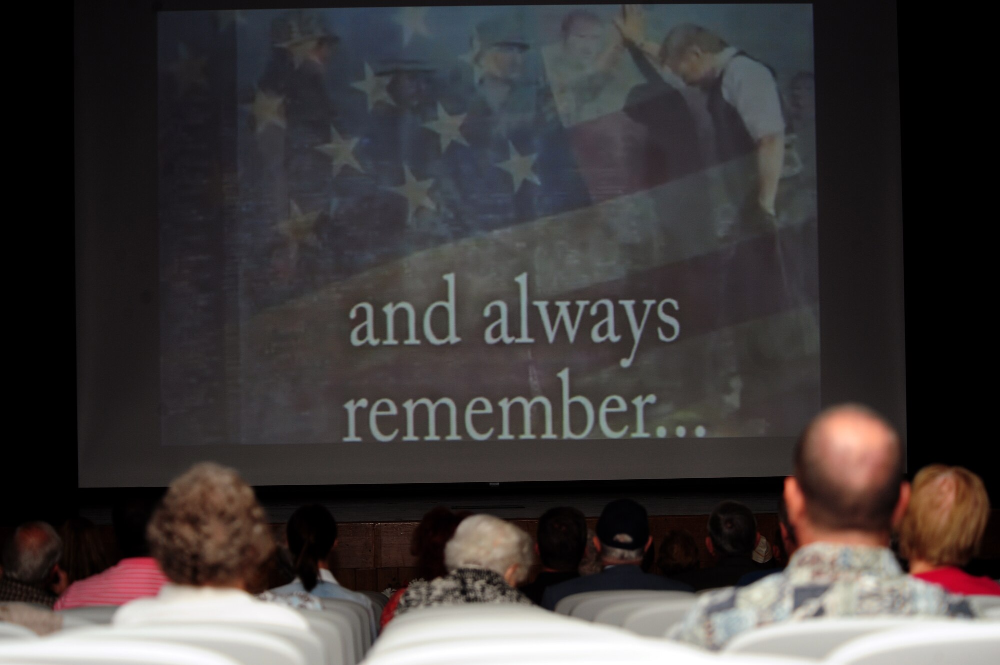 Audience members watch a slideshow presentation during the Wayne County Memorial Day Ceremony at Wayne Community College in Goldsboro, N.C., May 27, 2013. The presentation showcased photos and videos honoring the armed forces. (U.S. Air Force photo by Airman 1st Class John Nieves Camacho/Released)