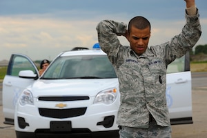 U.S. Air Force Staff Sgt. Trayshawn Humphries, 633rd Security Forces Squadron trainer, poses as a runaway in a high-risk traffic exercise in support of the Eagle Eyes program at Langley Air Force Base, Va., May 8, 2013. The Eagle Eyes program is designed to focus the eyes and ears of Airmen and community members on potential threats. (U.S. Air Force photo by Airman 1st Class Victoria H. Taylor/Released)
