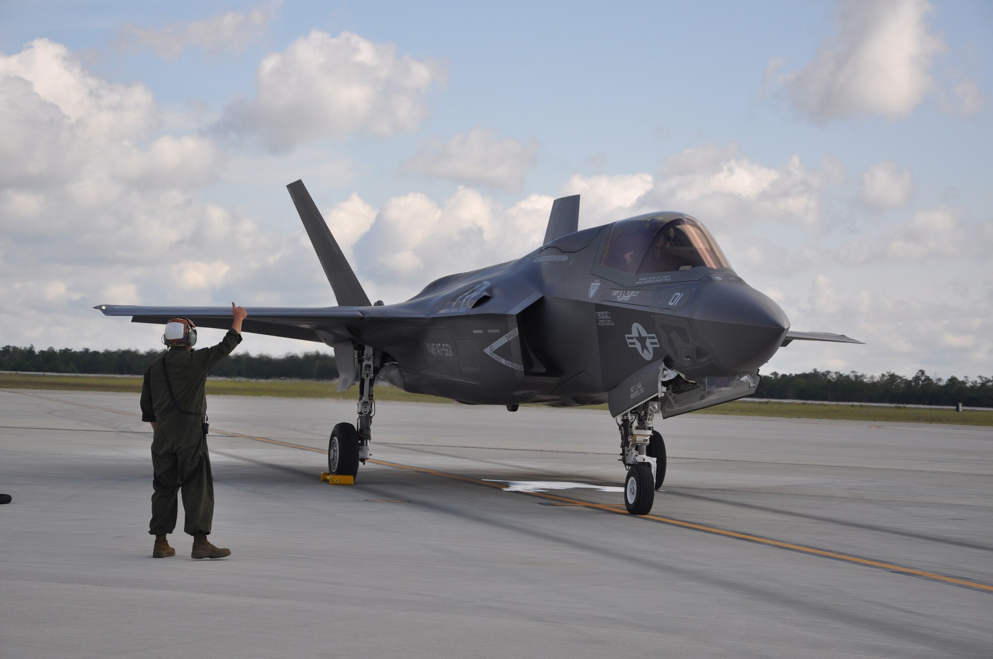 Marine Sgt. Robert Coates, an F-35B Lightning II maintainer, gives the thumbs up to Marine Capt. David Corkill piloting the joint strike fighter that he is cleared safe to resume his flying mission after hot refueling the aircraft. The F-35B and pilot were able to conduct a second training sortie after a quick ground refuel during the one-year anniversary of F-35B flying at Eglin Air Force Base, Fla. Eglin is the heart of F-35 training worldwide for the Air Force, Marines, Navy and international partner operators and maintainers of the Lightning II. U.S. Air Force photo/Maj. Karen Roganov)