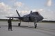 Marine Sgt. Robert Coates, an F-35B Lightning II maintainer, gives the thumbs up to Marine Capt. David Corkill piloting the joint strike fighter that he is cleared safe to resume his flying mission after hot refueling the aircraft. The F-35B and pilot were able to conduct a second training sortie after a quick ground refuel during the one-year anniversary of F-35B flying at Eglin Air Force Base, Fla. Eglin is the heart of F-35 training worldwide for the Air Force, Marines, Navy and international partner operators and maintainers of the Lightning II. U.S. Air Force photo/Maj. Karen Roganov)
