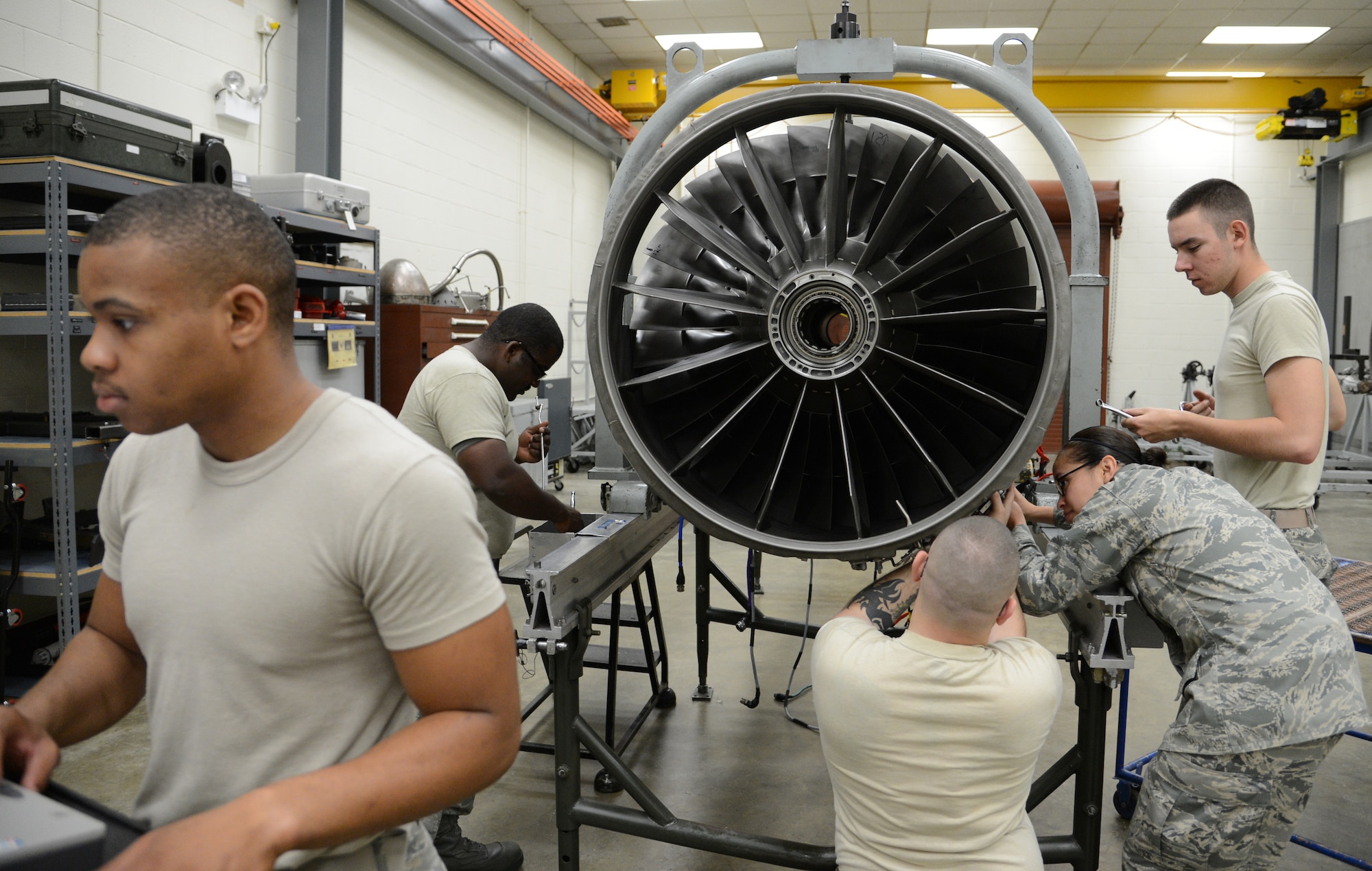 U.S. Air Force Airman 1st Class Bruce Smith works on the computer as Staff Sgt. Walter Buckner, Staff Sgt. Lloyd Jarell, Airman 1st Class Carissa Barrera, and Airman 1st Class Brenton Repine work on an F-16 Fighting Falcon engine during training at Detachment 202, 372nd Training Squadron, May 22, 2013, Shaw Air Force Base S.C. (U.S. Air Force photo by Airman 1st Class Jonathan Bass/Released)