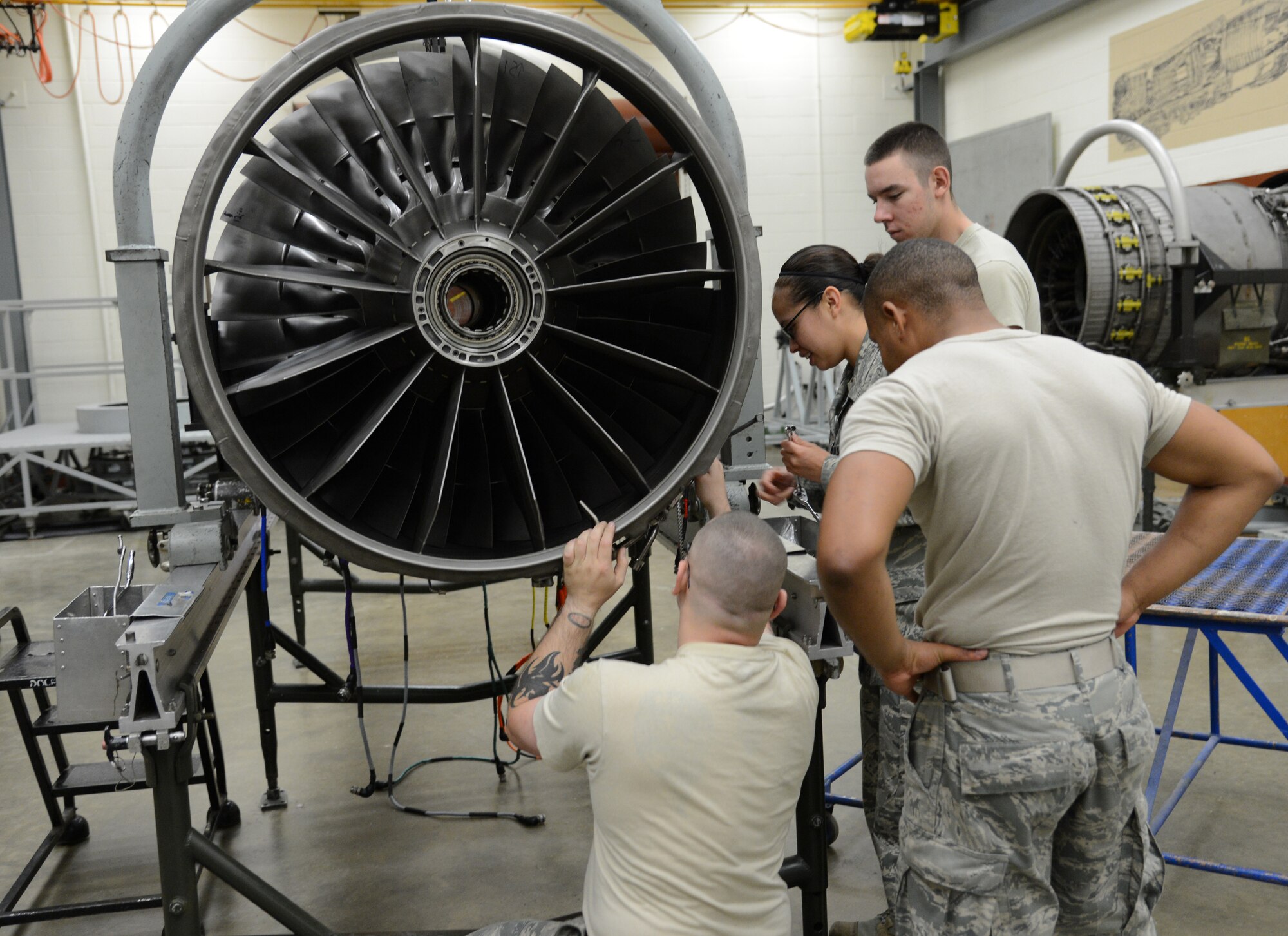 (Left to right) U.S. Air Force Staff Sgt. Lloyd Jarell, Airman 1st Class Carissa Barrera, Airman 1st Class Bruce Smith and Airman 1st Class Brenton Repine, F-16 maintainer students with Detachment 202, 372nd Training Squadron here, work on an F-16 Fighting Falcon engine on May 22, 2013 at Detachment 202, 372nd Training Squadron, Shaw Air Force Base, S.C. Students learn necessary skills in courses taught at the schoolhouse. (U.S. Air Force photo by Airman 1st Class Jonathan Bass/Released)