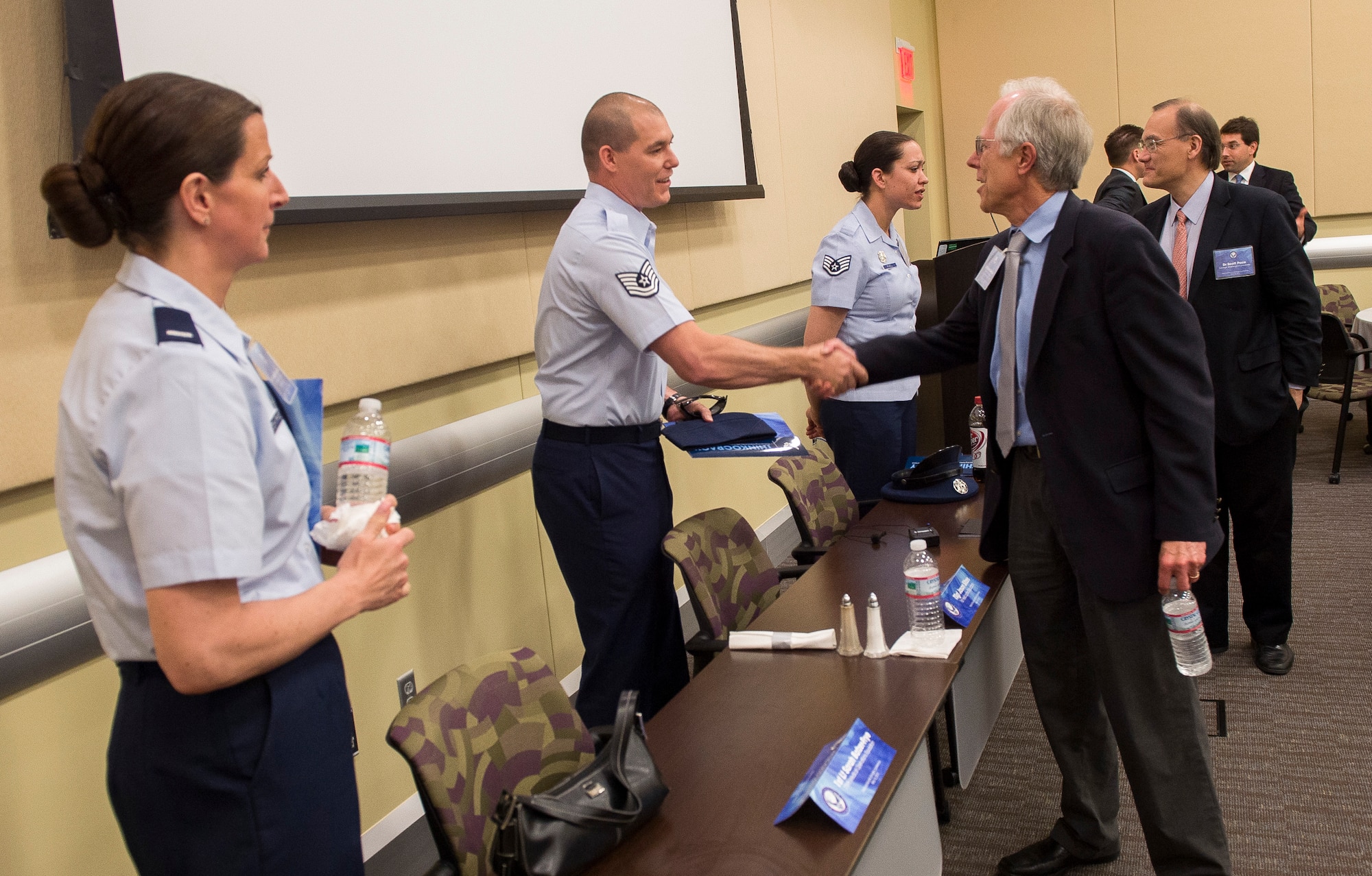 David Berteau (right) from the Center for Strategic and International Study an attendee of the annual National Security Scholars Conference being held at Joint Base Andrews, Md., on May 16, 2013, thanks Tech. Sgt. Jason Sitzes for his participation in the conference's Airmen's panel. The three-member panel composed of, from the left: 1st Lt. Sarah Batzer-Frye, a critical care nurse working for the tri-service team at Fort Belvoir Community Hospital, Fort Belvoir, Va., Tech. Sgt. Jason Sitzes, an evaluator flight engineer assigned to the 1st Helicopter Squadron, 11th Wing, Joint Base Andrews, Md., and Staff Sgt. Jennifer Powell, a pallbearer with the U.S. Air Force Honor Guard at Joint Base Anacostia-Bolling, Washington, D.C., talked about their experiences in the Air Force, then answered questions from the conference attendees. Jointly hosted by the Secretary of the Air Force Michael Donley and Air Force Chief of Staff Gen. Mark A. Welsh III, the annual forum brings Air Force senior leaders and foreign policy and international security experts together to discuss the Air Force's strategic direction and its contribution to national defense. (U.S. Air Force photo by Jim Varhegyi)