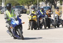 Senior Airman Mackenzie Orgren (right) negotiates a turn during a motorcycle safety rally held at the Joint Base San Antonio-Lackland Medina Annex April 12. (Air Force photo by Robbin Cresswell, JBSA-Lackland Public Affairs)