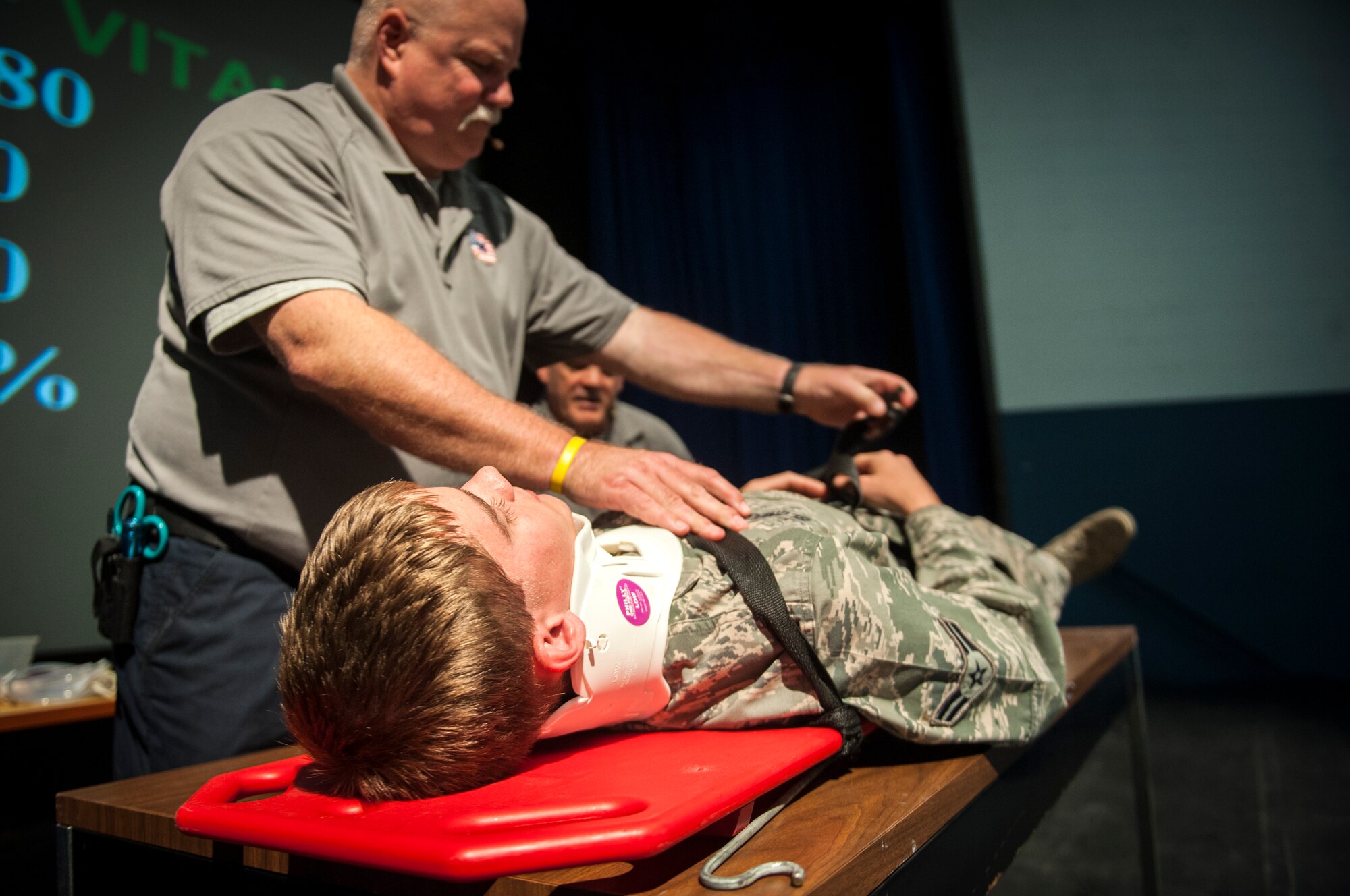 Greg McCarty, Street Smart presenter and retired Tampa Fire Rescue lieutenant, straps an Airman into a stretcher during a Street Smart presentation as part of Comprehensive Airman Fitness Day at Moody Air Force Base, Ga., May 17, 2013. The scenario depicted everything that first responders would do to a victim of a serious car accident.  (U.S. Air Force photo by Senior Airman Jarrod Grammel/Released)
