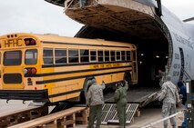 Air Force Personnel from the 76th Aerial Port Squadron and Travel Management Office here, and the 512th Airlift Wing, Dover Air Force Base, Delaware, guide a school bus up the nose ramp of a C-5M Super Galaxy aircraft here, May 24. The school bus, donated by Ohio-based charity Hope for Haiti’s Children, is being transported to Haiti via the Denton program.