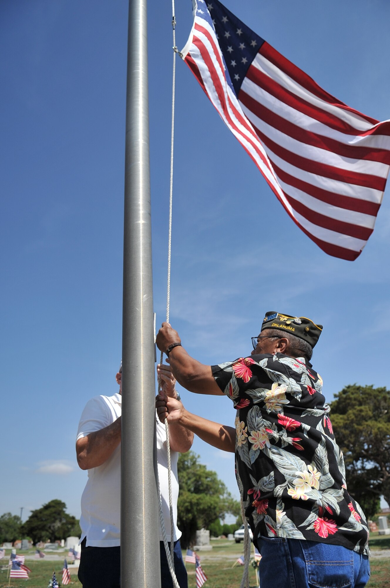 ALTUS, Okla. – Members of the Altus Veterans of Foreign Wars Post 4876 lower the United States Flag to half staff during a Memorial Day ceremony at the Veterans Garden Memorial Cemetery, May 27. The ceremony is held annually to honor past military members who sacrificed their lives. (U.S. Air Force photo by Senior Airman Dillon Davis/Released)
