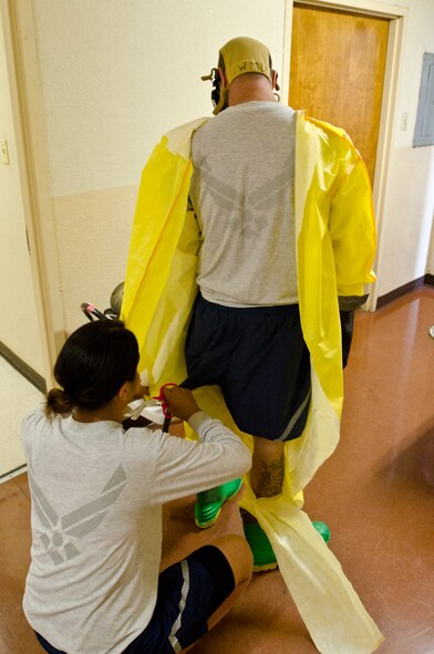A U.S. Airman assigned to the California National Guard’s Homeland Response Force (HRF) removes a protective suit from another Airman during a hazardous materials certification test at Naval Base Coronado, Calif., May 22, 2013. More than 100 Airmen from the Missouri and California National Guard’s HRF received emergency response training on natural disasters and domestic terrorist attacks. (U.S. Air National Guard photo by Tech. Sgt. Michael Crane/Released)