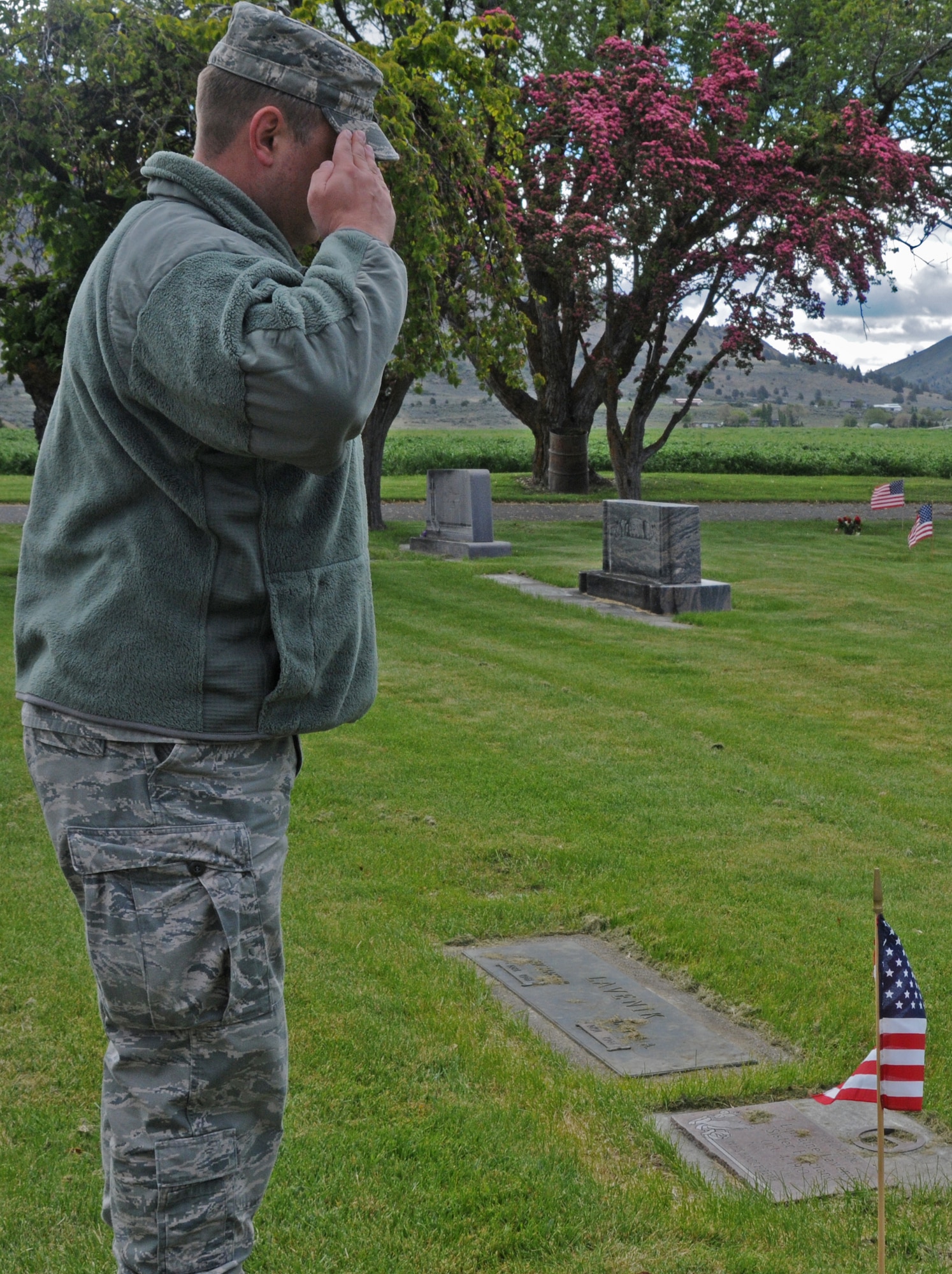 U.S. Air National Guard Master Sgt. Michael Shirar, 173rd Fighter Wing, salutes after placing a flag on the graves of local veterans at Mount Calvary Cemetery in Klamath Falls, Ore. May 23, 2013.  Members of the 173rd Fighter Wing spent their morning placing flags in honor of Memorial Day.  (U.S. Air National Guard photo by Master Sgt. Jennifer Shirar) RELEASED  